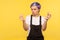 Portrait of upset young woman showing money gesture and looking dissatisfied. yellow background, studio shot