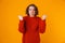 Portrait of uptight woman gesturing and yelling while standing isolated over yellow background