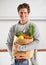Portrait, vegetables and man with brown paper bag, smile and home with nutrition and vegetarian. Face, person and guy