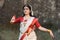 Portrait of very beautiful Indian girl dancer wearing traditional Indian saree and jewellery, in the posture of Indian dance.