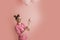 Portrait of very happy girl with balloons in her hands. Cheerfully young woman in rosy shirt on pink background