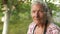 Portrait of a very old 80 year old woman in her garden. A close look, deep wrinkles, a headscarf, gray hair blowing the