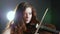 Portrait of violinist girl plays on wooden fiddle in studio on background of spotlights