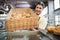 Portrait of waiter in apron showing basket of bread