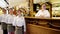 Portrait of a waiter, bartender, Cheerful restaurant staff smiling at camera in a restaurant, staff welcomes guests in