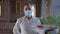 Portrait of waiter in Covid-19 face mask walking with dessert and salad on tray in slow motion leaving. Confident