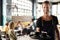 Portrait Of Waiter Serving Customers In Busy Coffee Shop