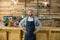 Portrait of waiter standing with hands on hip at counter