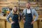 Portrait of waiter and waitress standing with hand on hip at counter