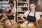 Portrait of waitress standing at counter with sandwiches and bread roll