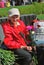 Portrait of a war veteran woman, she holds carnations and smiles.