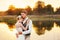 Portrait of a wedding couple against the background of the water at sunset sun. In the background a lake