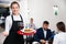 Portrait of welcoming female waiter who is standing in restaurante