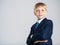 Portrait of white  kid in a blue business suit looking at camera.  Serious businessman  boy.  Blond boy with a confident look with