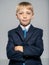 Portrait of white  kid in a blue business suit looking at camera.  Serious businessman  boy.  Blond boy with a confident look with