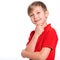 Portrait of white smiling kid in a red t-shirt looking away.  Photo of a thinking  boy looking at camera.  Caucasian boy with a