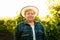 portrait of winemaker woman with hat looking at camera at sunset.