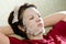 Portrait woman applying rejuvenating facial mask on her face