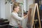 Portrait of a woman artist crayon painting in art studio