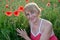 Portrait of the woman of average years with red poppies