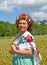 The portrait of the woman of average years with a wreath on the head stands in the blossoming buckwheat field