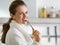 Portrait of woman in bathrobe eating breakfast