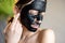 Portrait of a woman in black cleansing mask