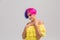 Portrait of a woman with bright colored hair, blue and pink haircut. girl with short hair dressed to yellow dress with