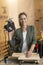 Portrait of woman carpenter with electric jigsaw and safety goggles in workshop