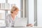 Portrait of woman checking their bills, Mature casual woman reading documents and working on a laptop in living room