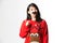 Portrait of woman in Christmas sweater standing with fake moustache