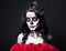 Portrait of woman with creative Halloween skull make up and red