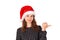 Portrait of woman in dress pointing left with thumb and confused. emotional girl in santa claus christmas hat isolated on white ba