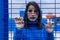 Portrait of a woman dressed and made up in blue behind a prison cell. concept of feminism, gender violence, women`s demands on