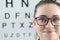 Portrait of woman with glasses on background of ophthalmic table