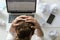 Portrait of a woman grabbing head at desk near the laptop