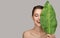 Portrait of woman and green leaf. Organic beauty.