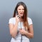 Portrait of woman having unpleasant phone call against gray background