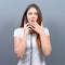 Portrait of woman having unpleasant phone call against gray background