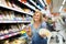 Portrait of woman holding assortment of cheese in grocery shop