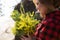 Portrait of a woman holding a bouquet of mimosa flowers.