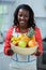 Portrait of woman holding bowl of fruits