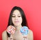 Portrait of woman holidng lollipops against red background