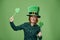 Portrait of woman with leprechaun`s hat and clover shaped banner