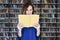 Portrait of woman in a library face half-covered by opened book, reading. College student in co-working, concept of studying