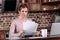 portrait of woman looking at camera while doing paperwork at table