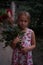 Portrait of a woman with lots of freshly picked up colorful dahlias and lush amaranth flower on rural farm during sunset