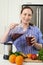 Portrait Of Woman Making Juice Or Smoothie In Kitchen