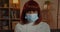 Portrait of woman in medical protective mask looking to camera. Close up view of female afro american person with red