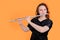 Portrait of a woman musician with a flute on a studio yellow background. Flutist with a large concert transverse flute in her